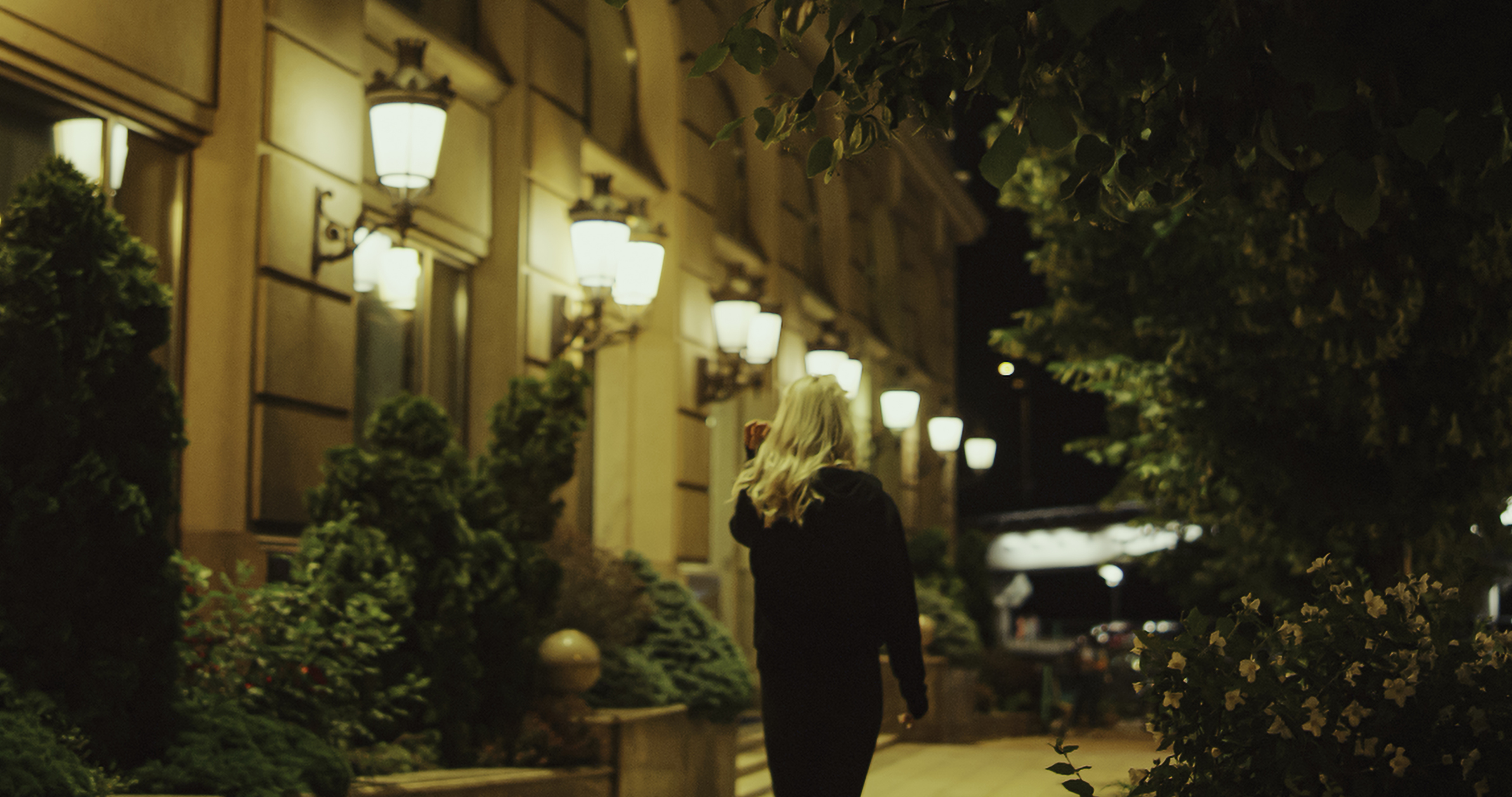 Woman going away street at late night in modern city outdoors.