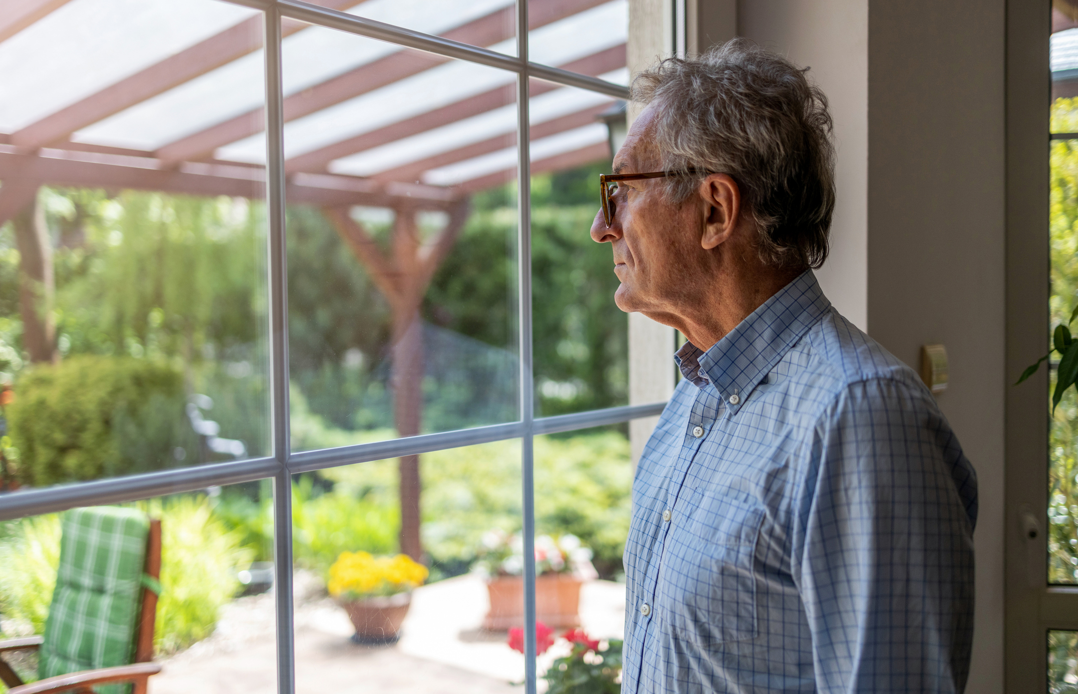 Senior man looking out of window at home