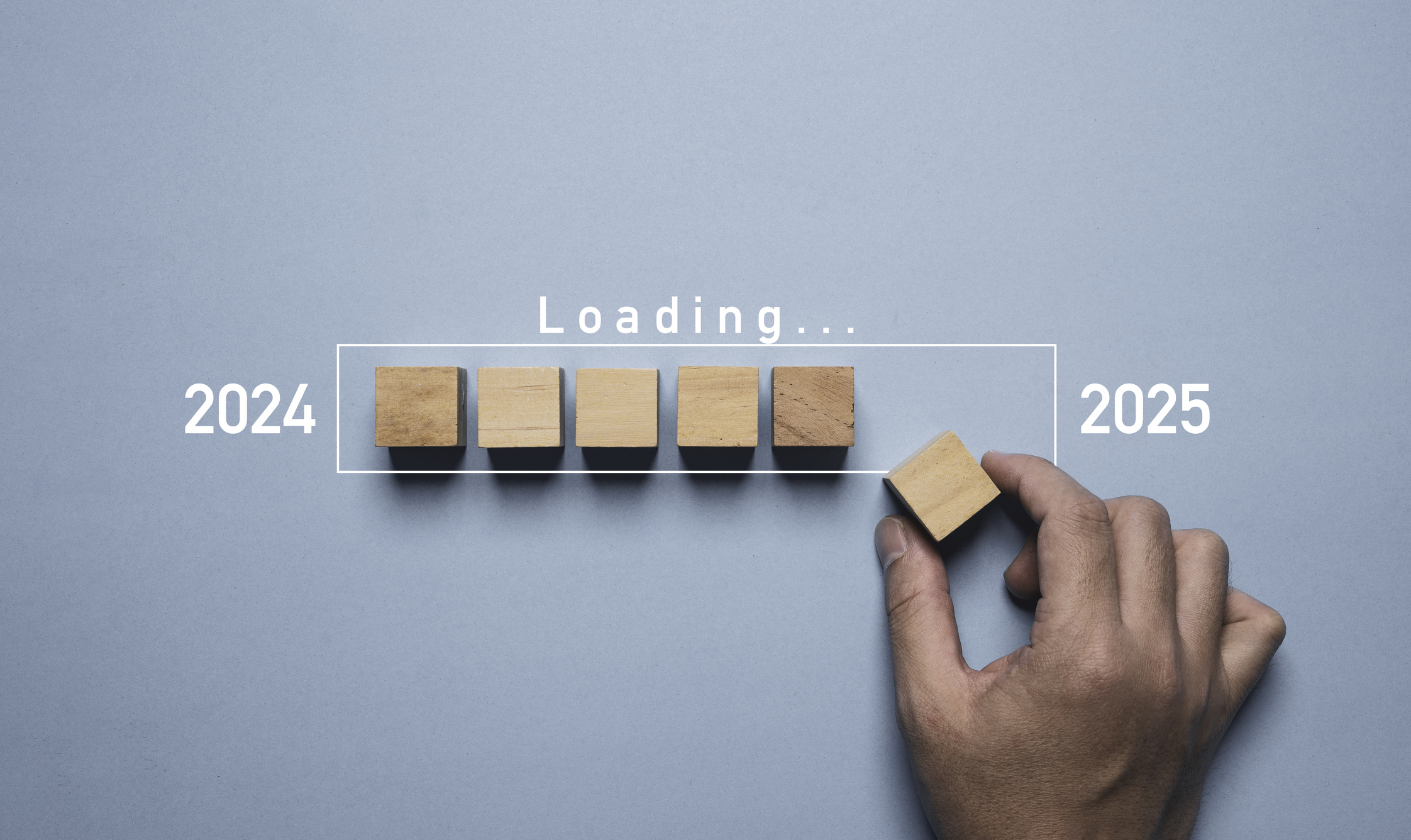 Hand assemble wooden block cube to update technology downloading tool bar status from 2024 to 2025 , Merry Christmas and happy new year concept.