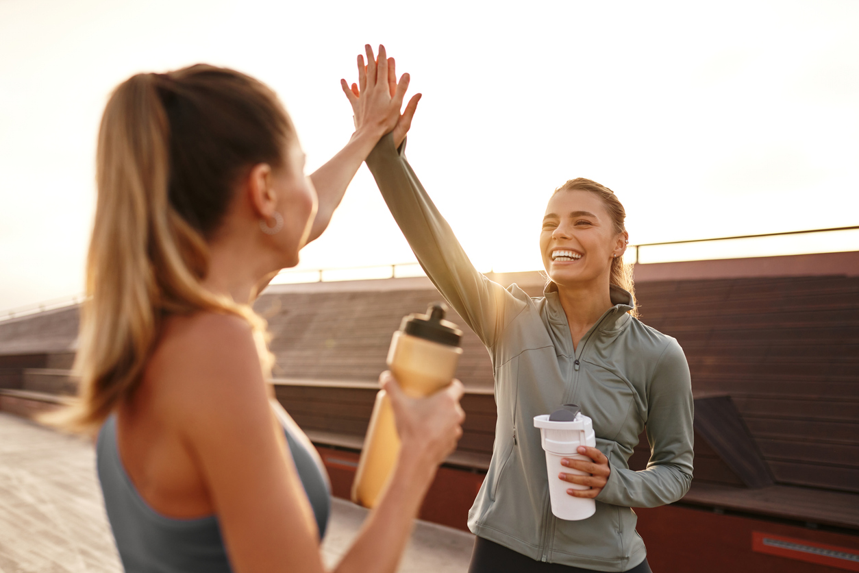 Celebrating Fitness Friends Sharing Joyful HighFives After Completing Their Workout Session